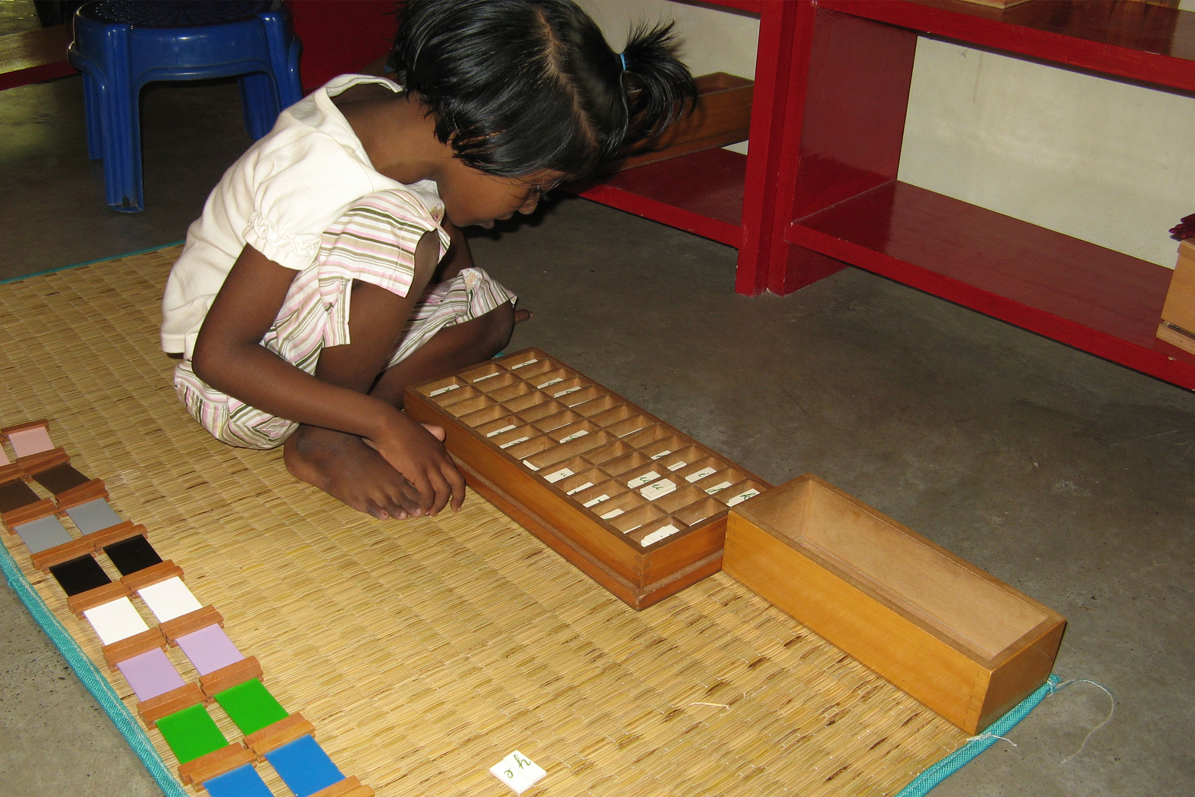 Child working on Montessori Moveable Alphabet material