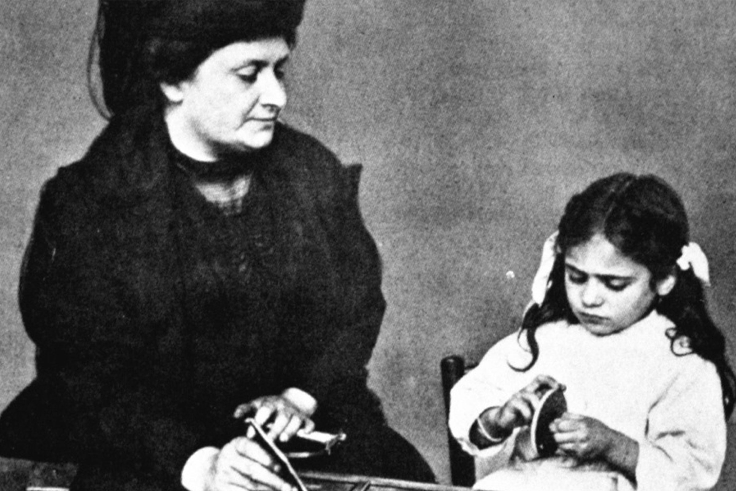 Maria Montessori working with young child
