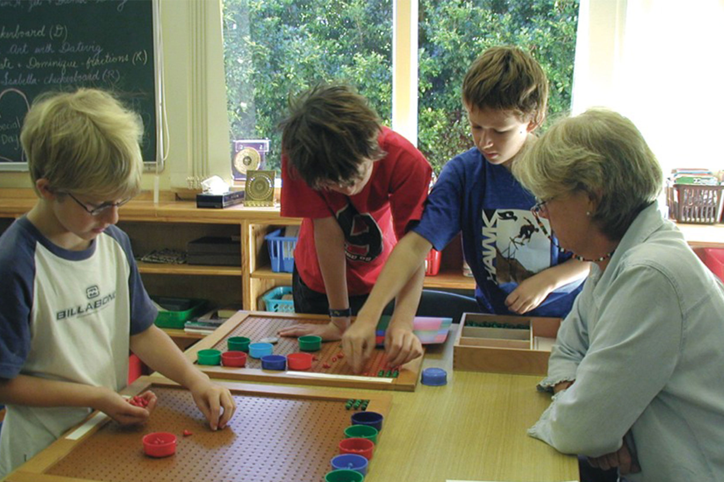 Montessori teacher observing group of primary children